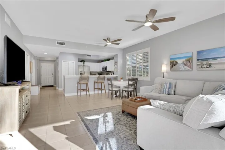 Living room featuring light tile patterned floors and a ceiling fan