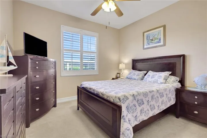 Bedroom with light colored carpet and ceiling fan