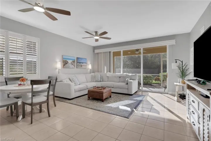 Living area featuring light tile patterned floors and a ceiling fan