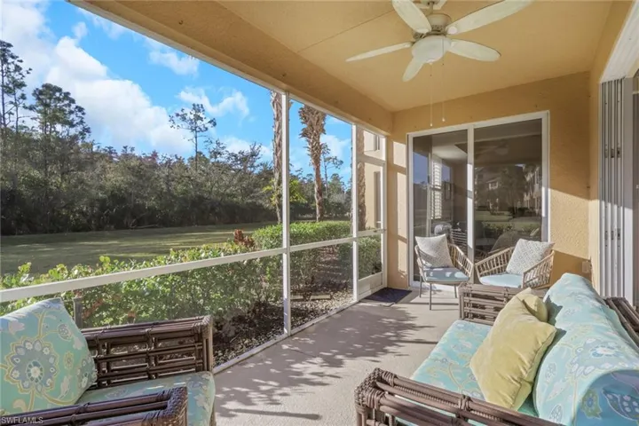 Sunroom / solarium with a ceiling fan, an outdoor hangout area, and view of scattered trees