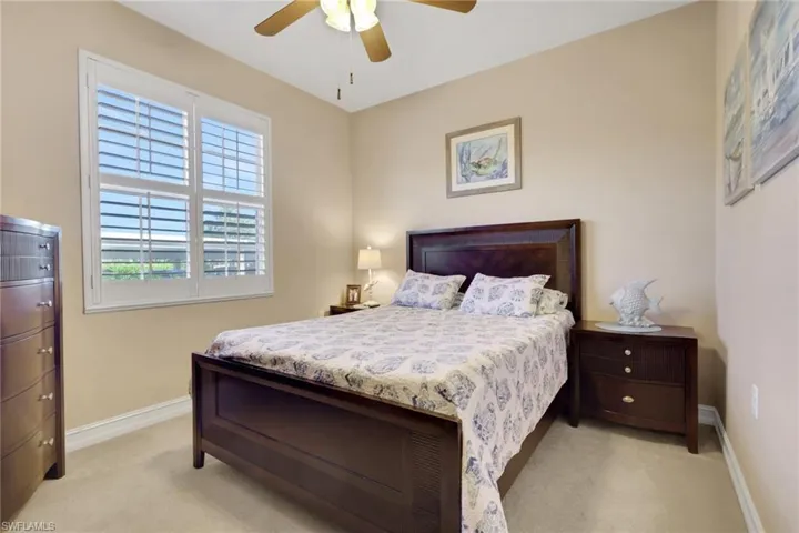Bedroom featuring a ceiling fan and light colored carpet