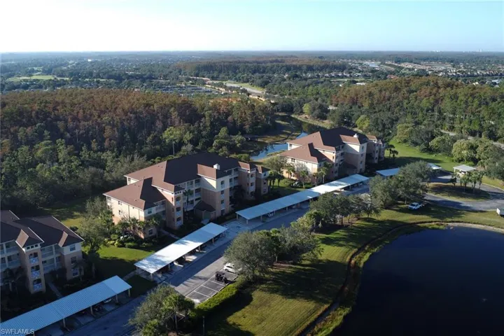 Drone / aerial view of a nearby body of water and apartment complex / building