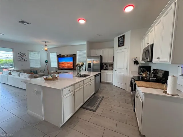 Central kitchen island featuring a substantial countertop and an undermount sink