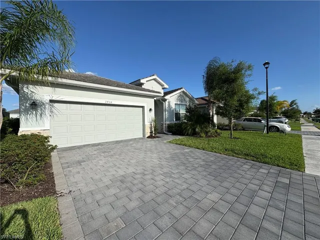 Paver driveway leading to a two-car garage
