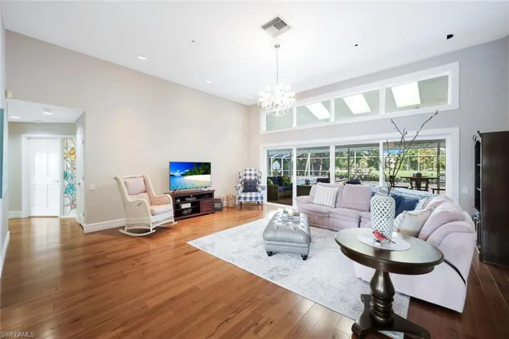 Living Room Next to The Entry Foyer, Real Wood Flooring, High Ceilings, Transom Windows, Sliders Hallway to Powder Room, and Primary Wing
