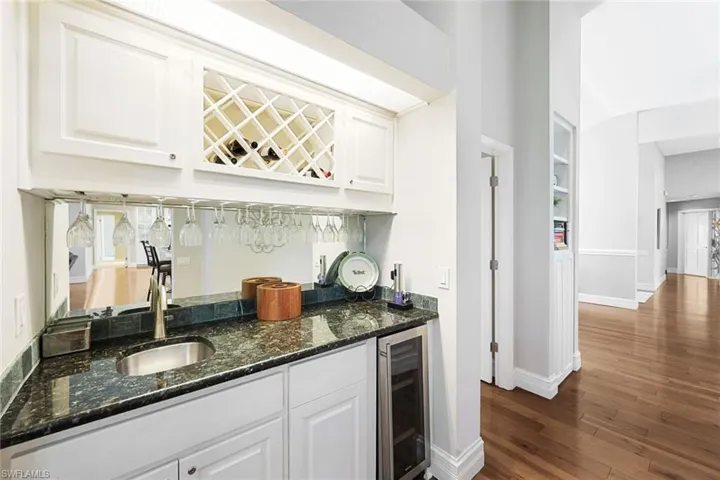 Family Room Wet Bar, Quartz, Wine Storage, Wine Cooler- Doorway Before leads to Laundry Room, Garage, Bedroom with a Private Full Bath