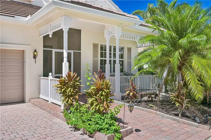 View of exterior entry with stucco siding, covered porch, and a garage