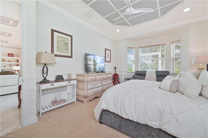 Bedroom with light colored carpet, ornamental molding, a wainscoted wall, recessed lighting, and a decorative wall