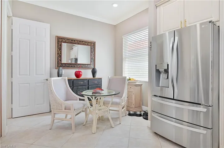 Dining area with light tile patterned floors and ornamental molding