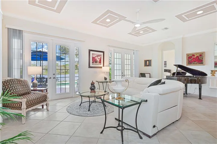 Living area with french doors, ornamental molding, recessed lighting, light tile patterned floors, and ceiling fan