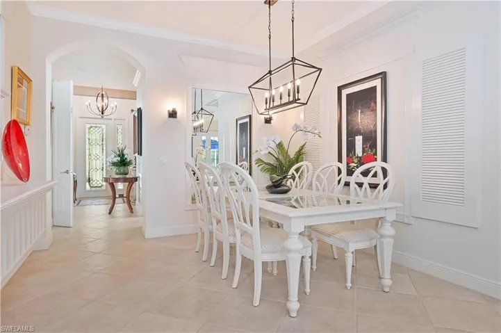 Dining area featuring a chandelier, light tile patterned floors, and crown molding