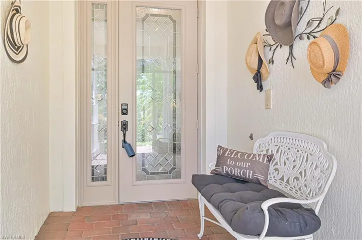 Doorway to outside with brick flooring and a textured wall