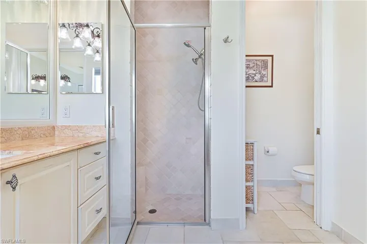 Bathroom with vanity, a stall shower, and light tile patterned flooring