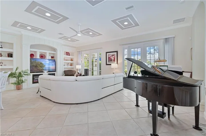 Living area with ornamental molding, built in shelves, french doors, light tile patterned flooring, and recessed lighting