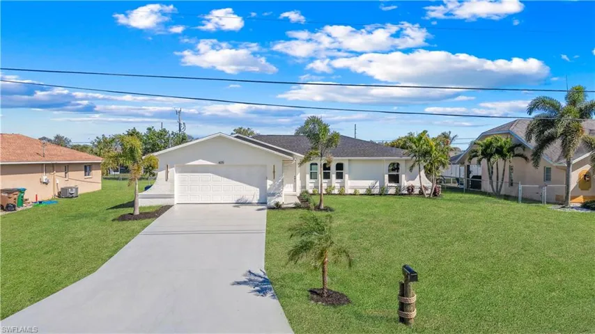 Ranch-style home featuring a garage, central AC, and a front lawn