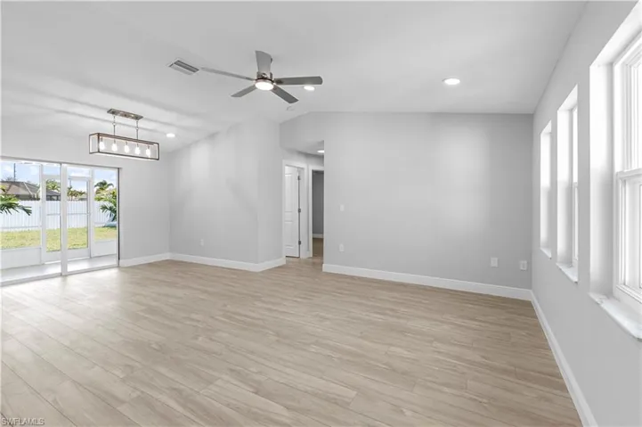 Spare room featuring lofted ceiling, light hardwood / wood-style flooring, and ceiling fan