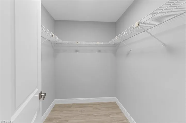 Walk in closet with wood-type flooring