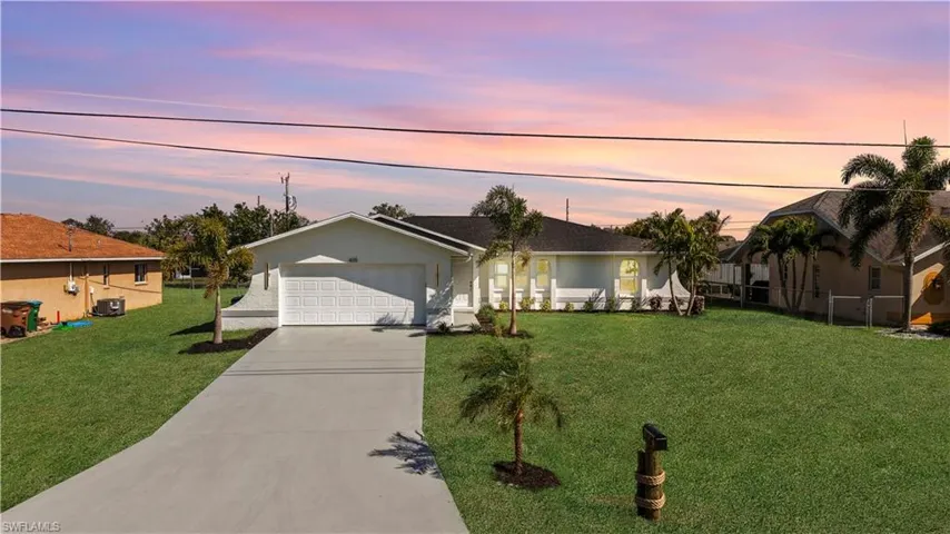 Ranch-style house with central AC, a garage, and a yard