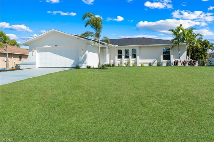 Ranch-style home featuring a garage and a front lawn