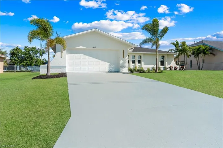 Ranch-style house featuring a garage and a front lawn