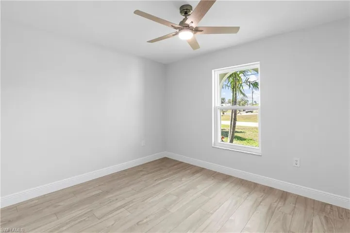 Empty room with light hardwood / wood-style flooring and ceiling fan