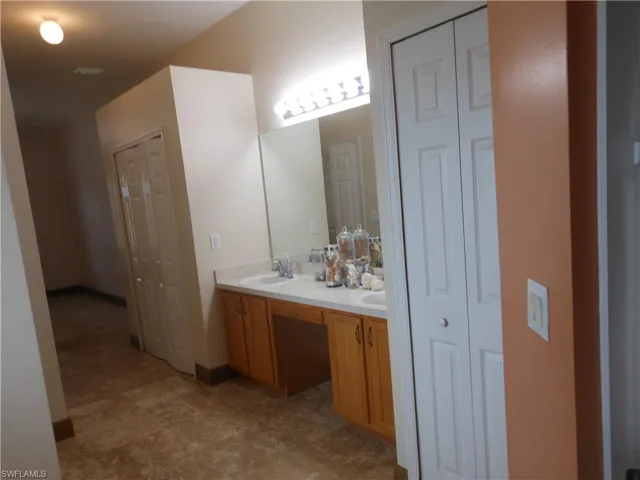 Full bathroom featuring a closet and double vanity