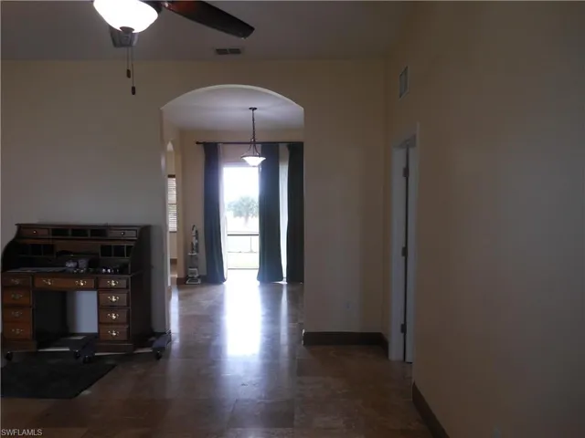 Hallway featuring arched walkways and baseboards