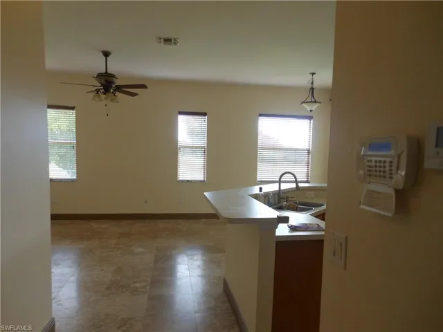 Kitchen featuring decorative light fixtures, plenty of natural light, light countertops, and ceiling fan