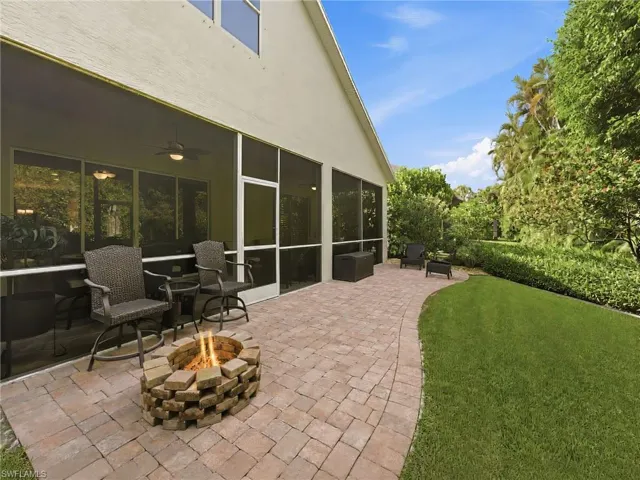 Expansive paver patio featuring a built-in fire pit