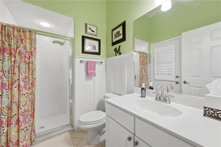 POOL BATH - Bathroom featuring a single vanity with an integrated sink, polished chrome faucet, and a large wall-mounted mirror
