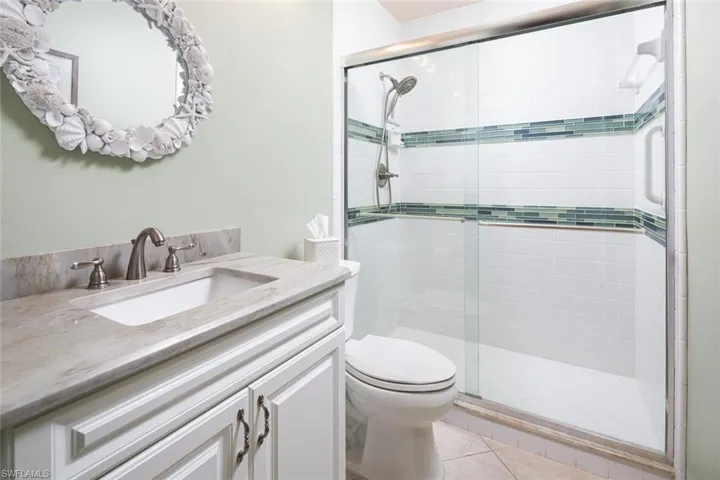 Bathroom with toilet, tile patterned floors, a shower stall, and vanity