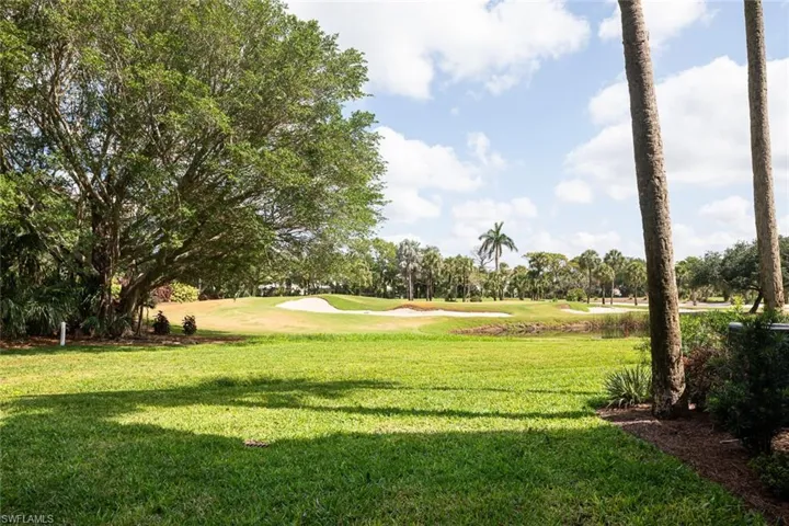 View of property's community featuring a lawn and view of golf course