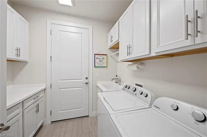 Laundry room with separate washer and dryer and cabinet space