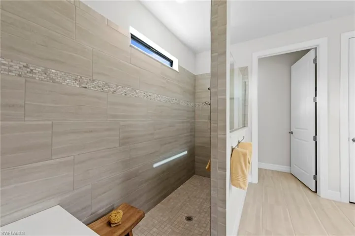 Bathroom featuring walk in shower and baseboards
