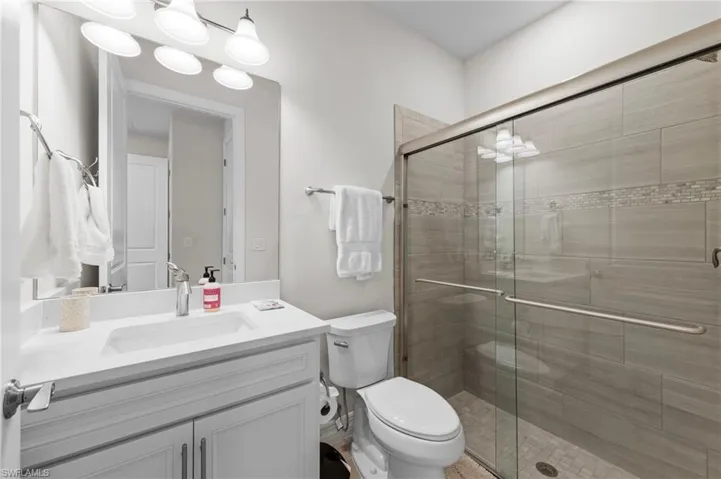 Full bath with a shower stall and vanity