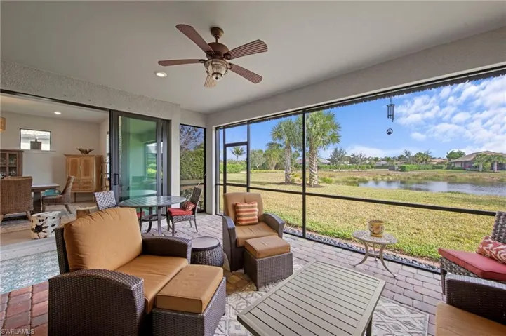Sunroom / solarium featuring a water view, an outdoor living space, and a ceiling fan