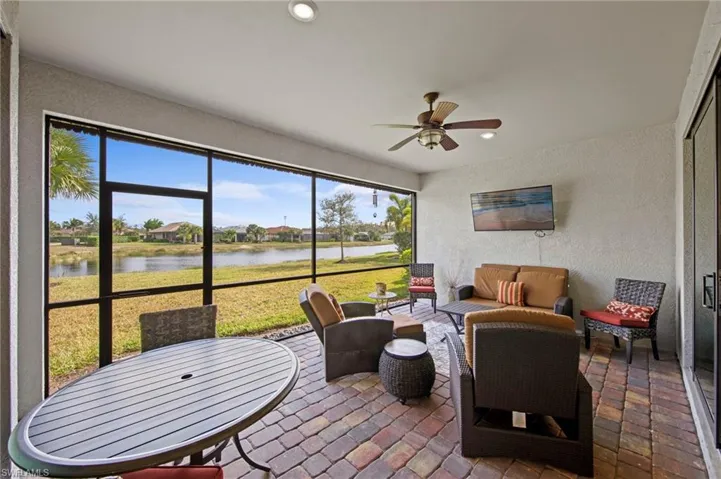 Sunroom with a textured wall, outdoor lounge area, brick flooring, a ceiling fan, and recessed lighting