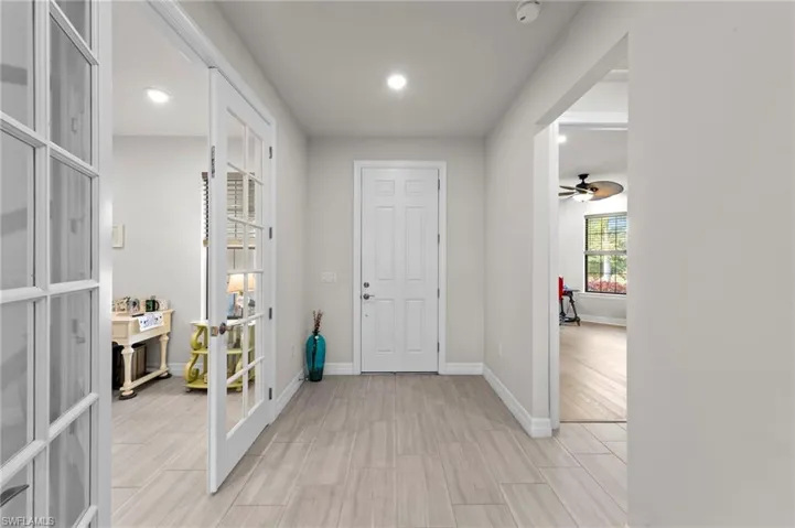 Foyer entrance featuring wood tiled floors, ceiling fan, french doors, and recessed lighting