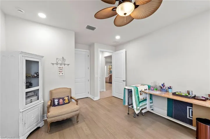 Office area featuring light wood-style floors, a ceiling fan, and recessed lighting