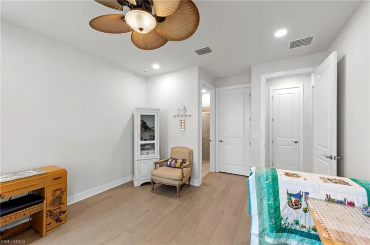 Bedroom featuring light wood-style flooring, ceiling fan, recessed lighting, and ensuite bath