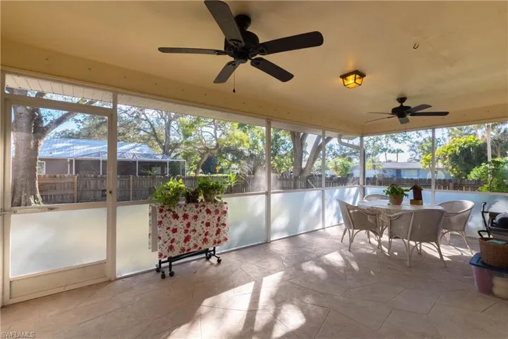 Living room with vaulted ceiling, light tile patterned floors, and ceiling fan
