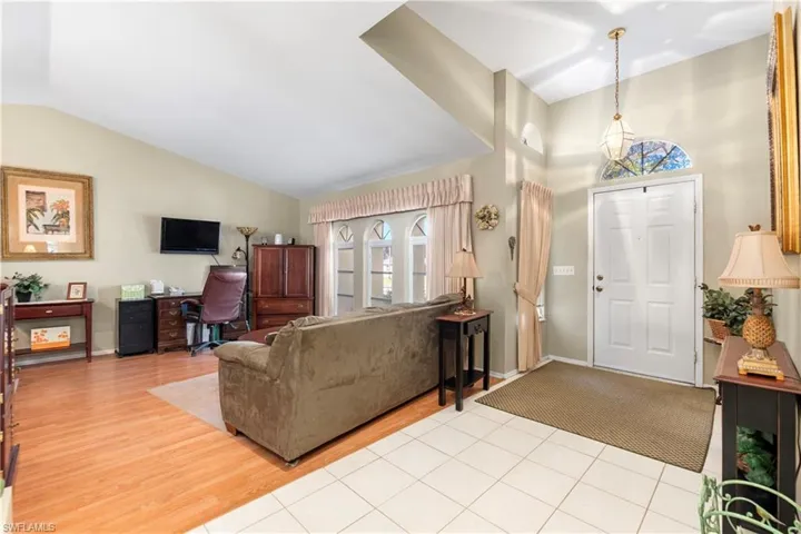 Living room with light hardwood / wood-style flooring and vaulted ceiling
