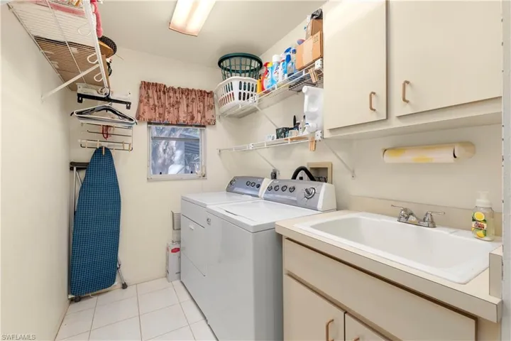 Kitchen featuring stainless steel appliances, a sink, light countertops, a breakfast bar, and light tile patterned floors