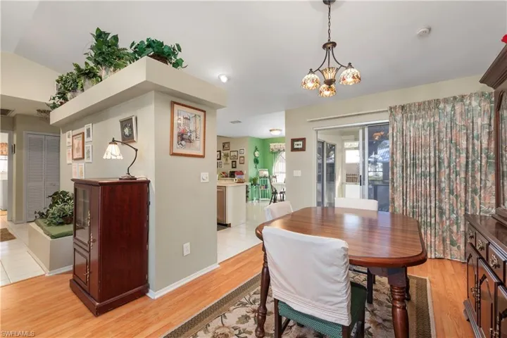 Dining space featuring an inviting chandelier, light hardwood / wood-style floors, and vaulted ceiling