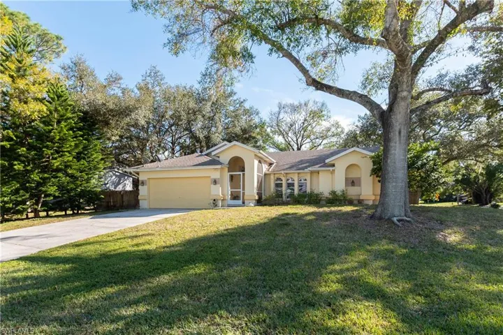 Single story home with a garage and a front yard