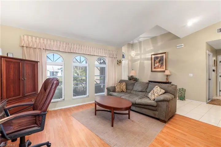 Dining area featuring vaulted ceiling, a notable chandelier, and light wood-type flooring