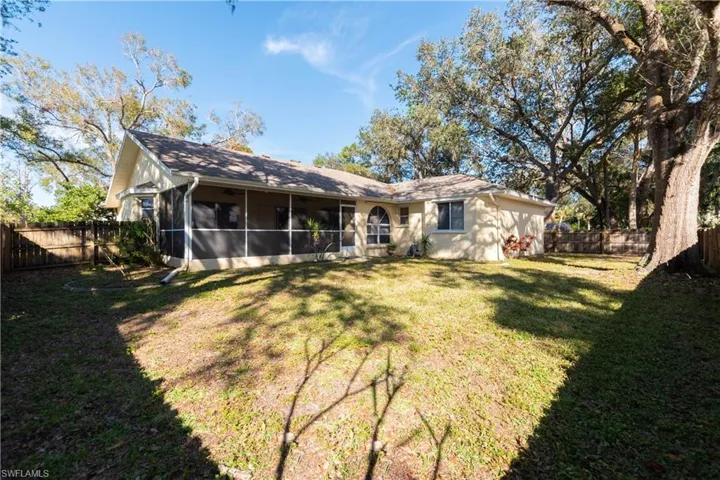 Back of property featuring a yard and a sunroom