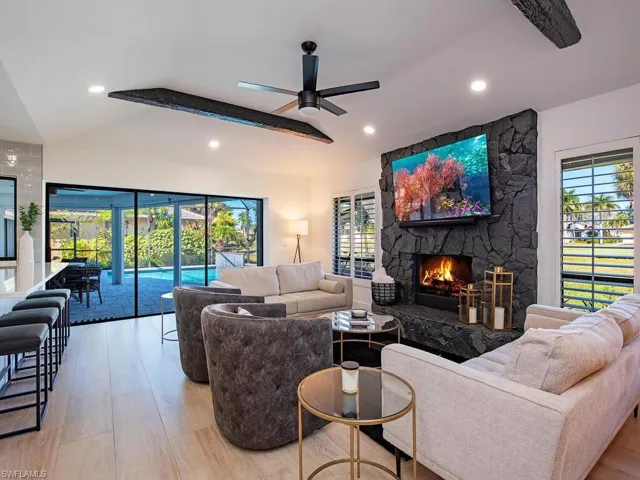 Living area featuring a ceiling fan, light wood-plank tile flooring, a wood burning fireplace, and recessed lighting
