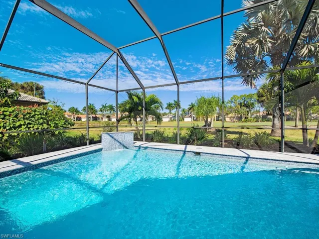 Outdoor heated pool with custom water feature on golf course