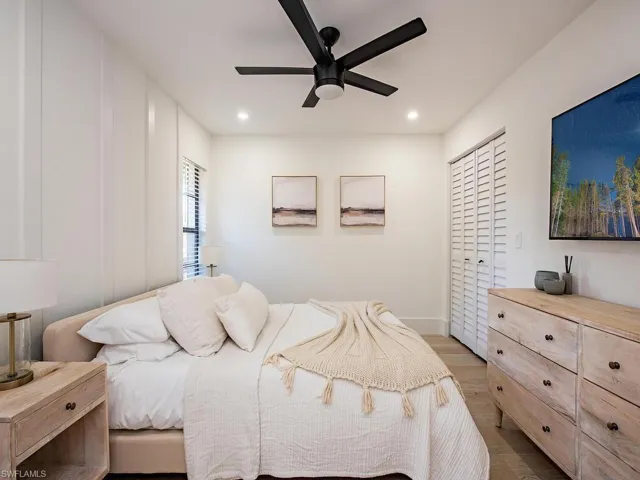 Bedroom with wood-plank tile finished floors, ceiling fan, a closet, custom accent wall and recessed lighting